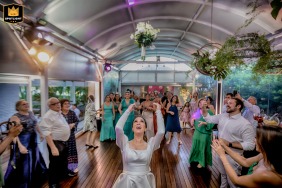 At Merci - Casa de Eventos, a beautiful wedding venue, the bride tosses her bouquet into the air, capturing the excitement and anticipation of who will be the next to tie the knot.